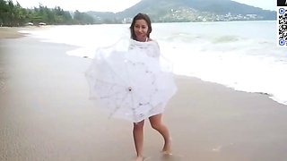 Brown haired girl taunts on a sunny beach
